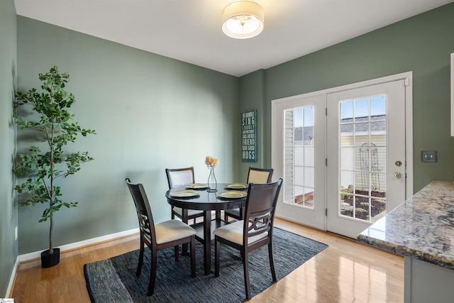 dining area featuring light wood finished floors and baseboards