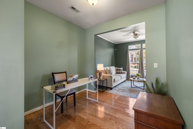 office space with visible vents, a ceiling fan, baseboards, and wood finished floors