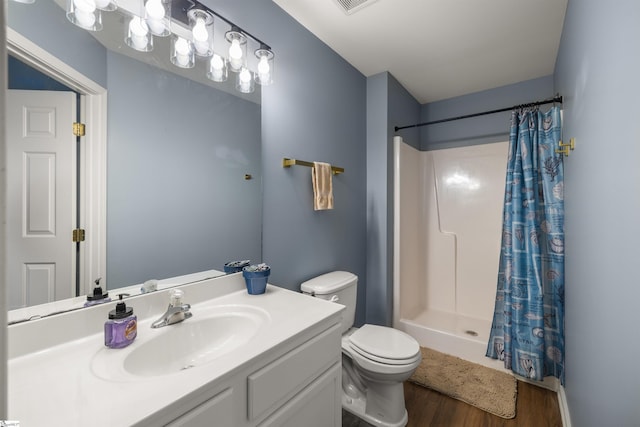 bathroom with toilet, vanity, a shower with curtain, and wood finished floors