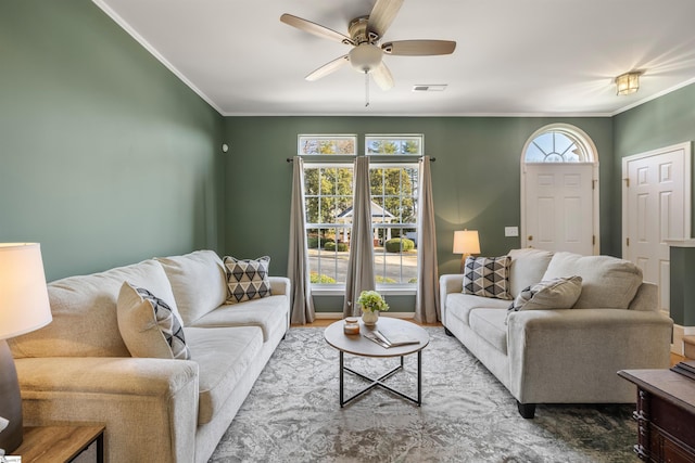 living area featuring visible vents, plenty of natural light, and ornamental molding