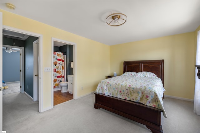 bedroom featuring attic access, connected bathroom, baseboards, and light carpet