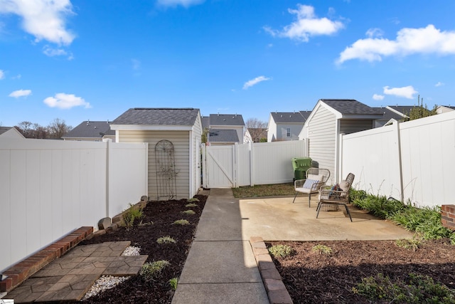 view of yard with a fenced backyard, a patio, and a gate