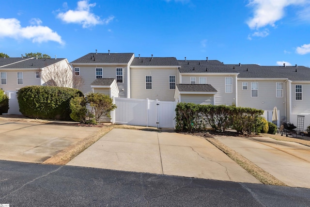 exterior space with a residential view, fence, and a gate