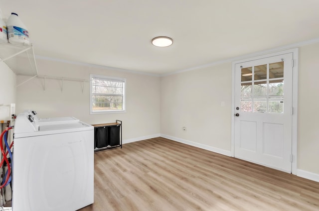 laundry area featuring light wood finished floors, laundry area, washing machine and dryer, and baseboards