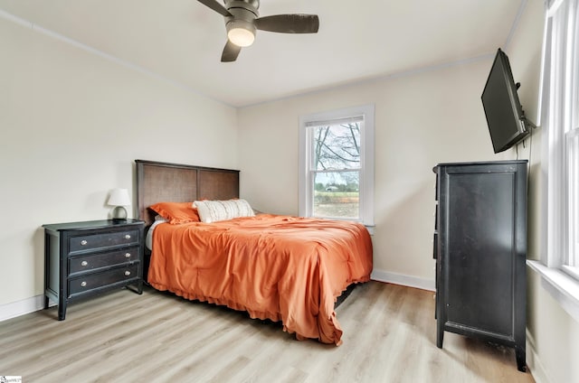 bedroom with light wood-style flooring, baseboards, and ceiling fan