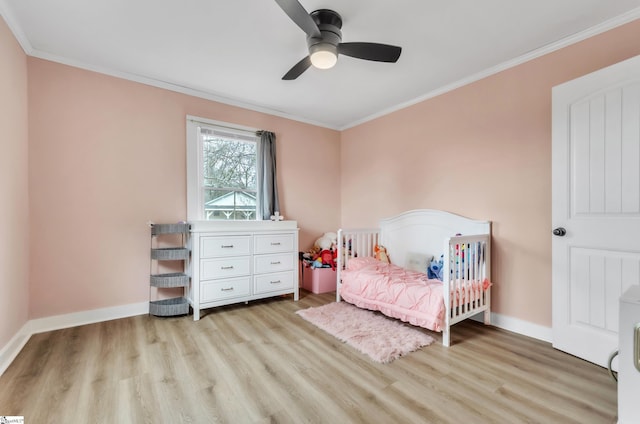 bedroom featuring baseboards, light wood-style floors, and ornamental molding