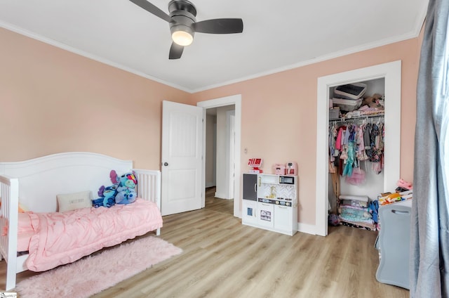 bedroom featuring light wood-type flooring, a ceiling fan, a closet, and crown molding