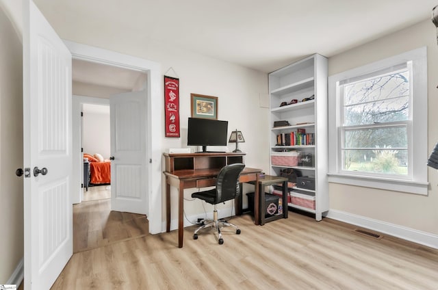 office space featuring visible vents, light wood-type flooring, and baseboards