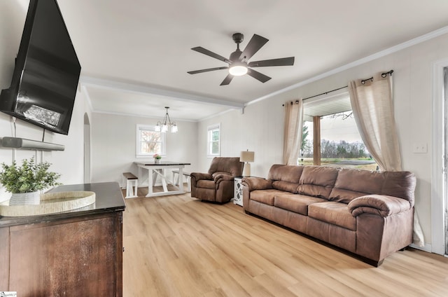 living area featuring ceiling fan with notable chandelier, arched walkways, crown molding, and light wood finished floors