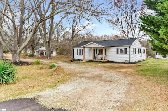 view of front of home featuring covered porch, a front yard, and dirt driveway