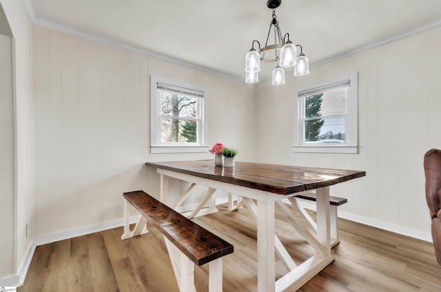 dining space with a chandelier, light wood-style flooring, crown molding, and baseboards