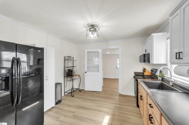 kitchen featuring dark countertops, ornamental molding, black appliances, and a sink