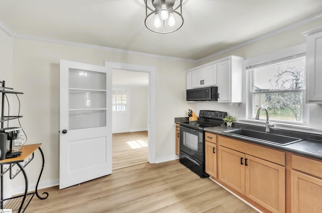 kitchen with black appliances, crown molding, dark countertops, and a sink