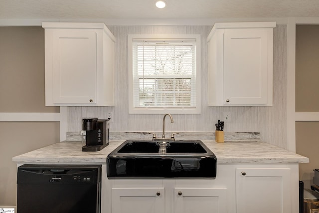 kitchen featuring white cabinetry, black dishwasher, and a sink