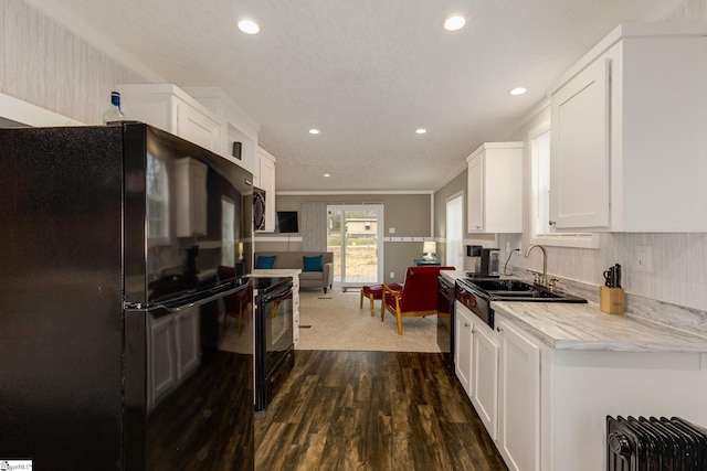 kitchen with recessed lighting, a sink, black appliances, white cabinets, and dark wood-type flooring