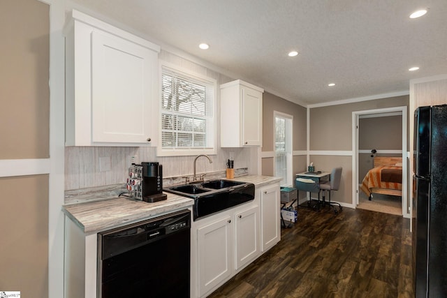 kitchen with dark wood finished floors, a sink, black appliances, white cabinets, and backsplash