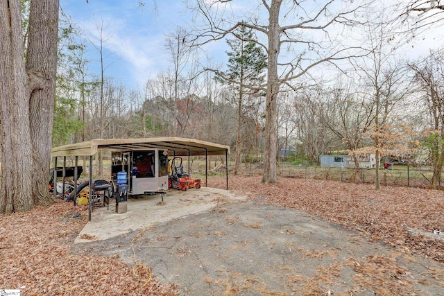 exterior space with a carport, aphalt driveway, and fence