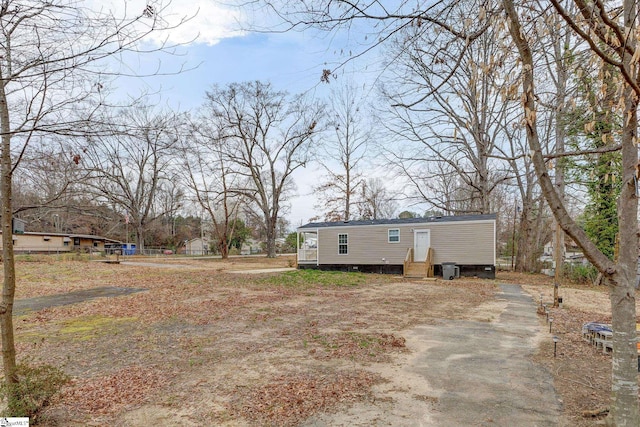 view of yard featuring driveway and entry steps