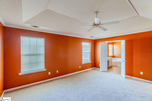 unfurnished bedroom featuring visible vents, light carpet, ornamental molding, connected bathroom, and baseboards