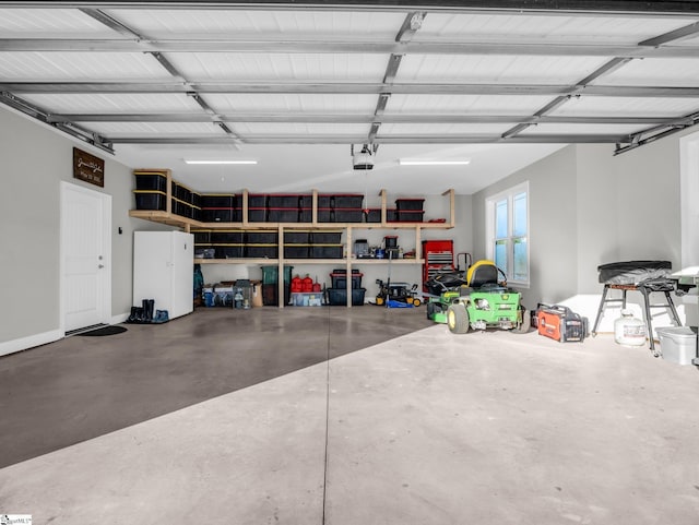 garage featuring a garage door opener and freestanding refrigerator