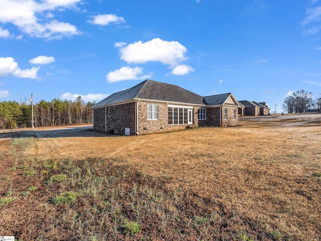 view of property exterior with a lawn and crawl space