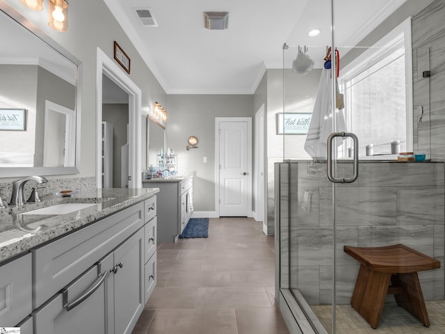 bathroom with two vanities, a shower stall, crown molding, and a sink