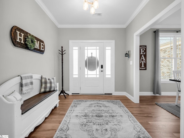 entryway with visible vents, baseboards, wood finished floors, and crown molding