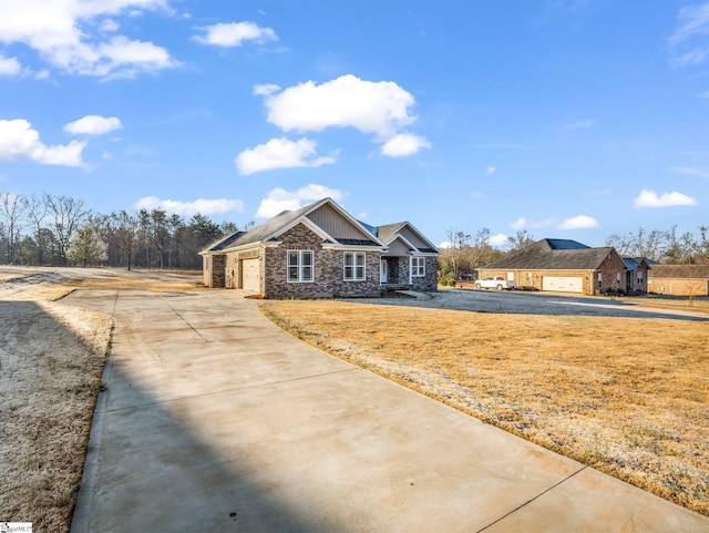 craftsman-style house featuring stone siding, concrete driveway, and an attached garage