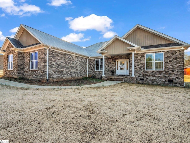 view of front of property with crawl space, brick siding, and a shingled roof