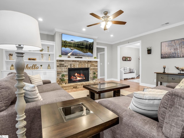 living area featuring visible vents, wood finished floors, a ceiling fan, and ornamental molding