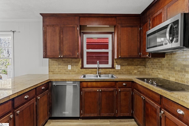 kitchen featuring a sink, stainless steel appliances, decorative backsplash, and light countertops