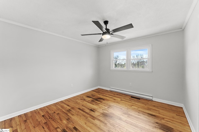 spare room with a baseboard radiator, baseboards, wood finished floors, and ornamental molding