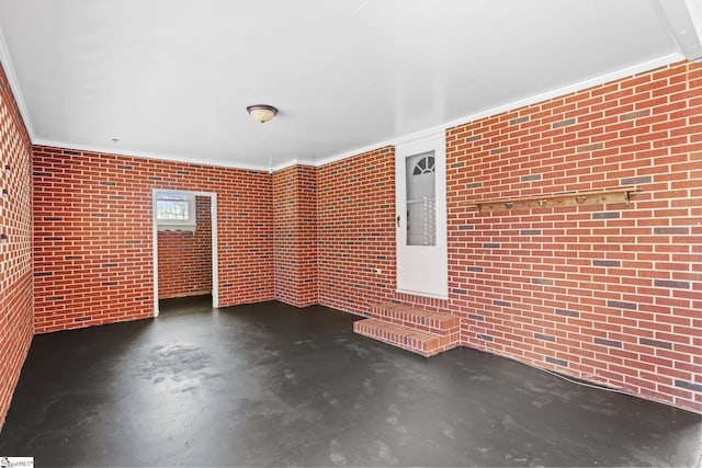 interior space featuring concrete floors, brick wall, and crown molding