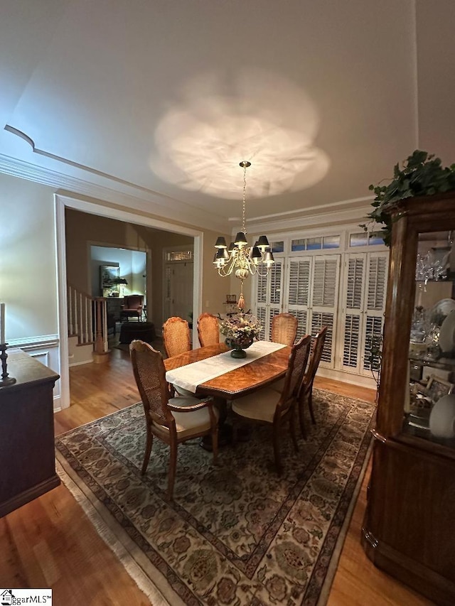 dining room featuring crown molding, a notable chandelier, and light wood-type flooring