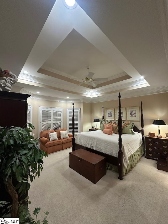 bedroom with a raised ceiling, carpet flooring, and crown molding