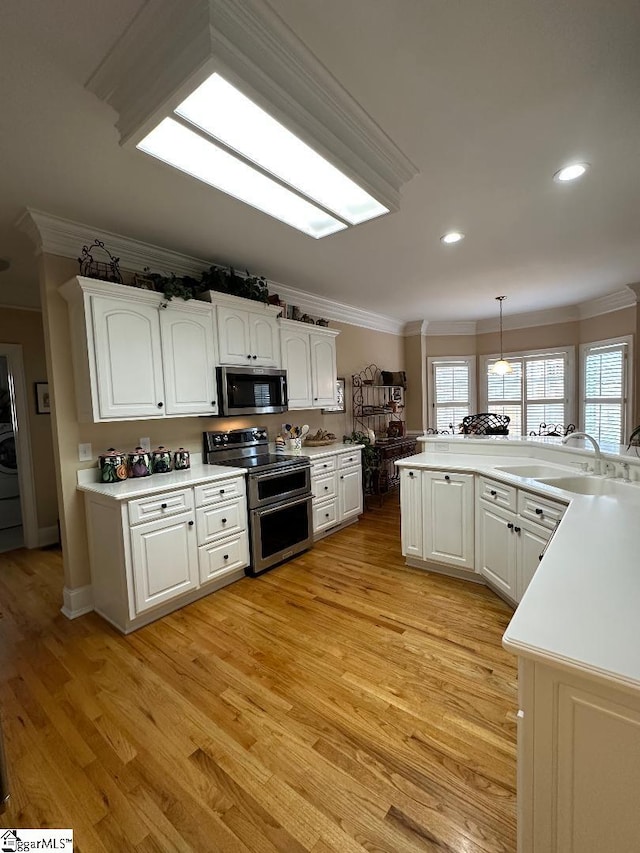 kitchen featuring a sink, appliances with stainless steel finishes, ornamental molding, and white cabinets