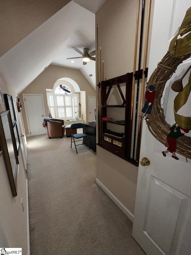 hall with baseboards, lofted ceiling, and carpet floors