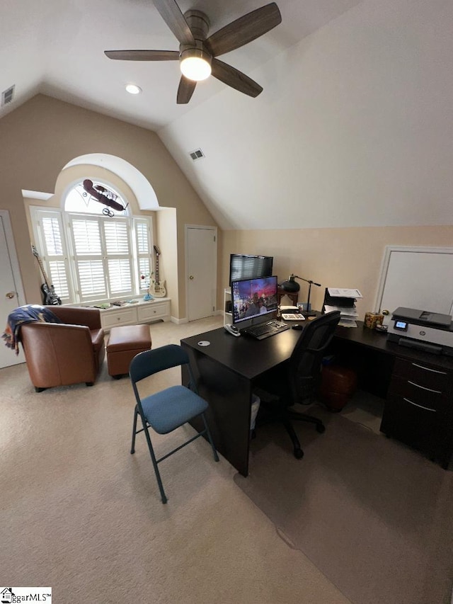 carpeted home office with vaulted ceiling, visible vents, and ceiling fan