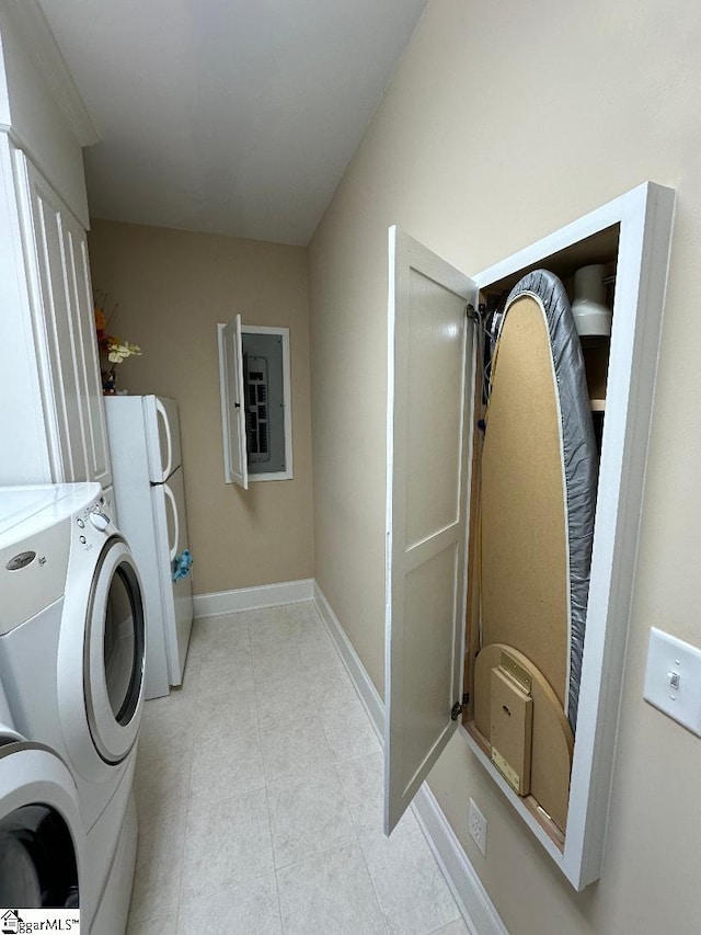 washroom with washer and dryer, baseboards, light tile patterned flooring, and laundry area