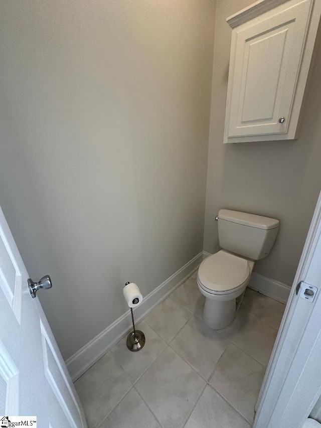 bathroom featuring tile patterned flooring, toilet, and baseboards