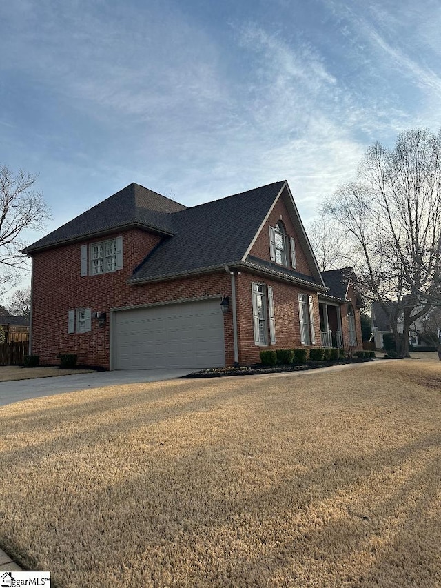 view of front of property with driveway, brick siding, an attached garage, and a front lawn