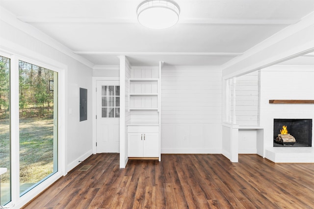 unfurnished living room with dark wood-type flooring, baseboards, beamed ceiling, electric panel, and a fireplace