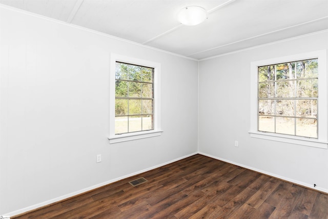 spare room with visible vents, baseboards, dark wood-type flooring, and ornamental molding