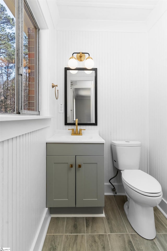 bathroom featuring vanity, toilet, and baseboards