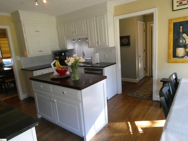 kitchen with dark countertops, white cabinets, and dark wood finished floors