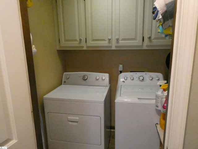 clothes washing area featuring washer and dryer and cabinet space