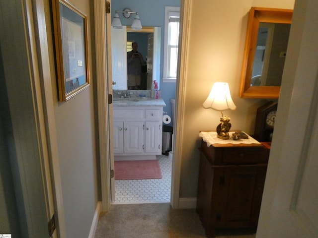 hall with baseboards and a sink