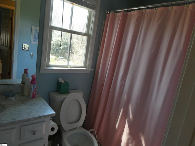 bathroom featuring a shower with shower curtain, toilet, and vanity