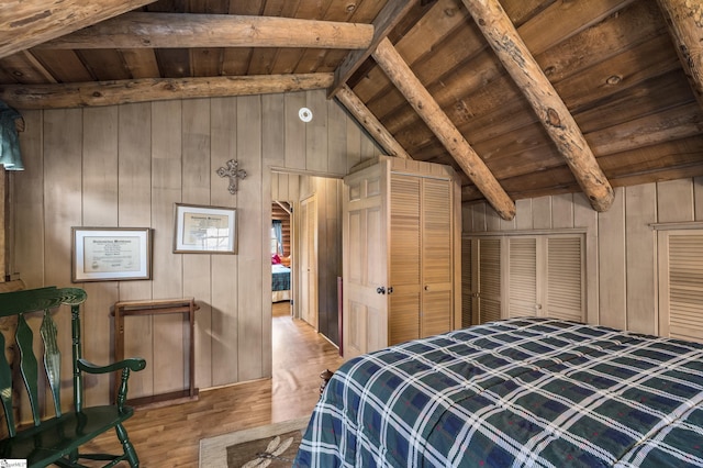 unfurnished bedroom featuring lofted ceiling with beams, wooden walls, wood ceiling, and wood finished floors