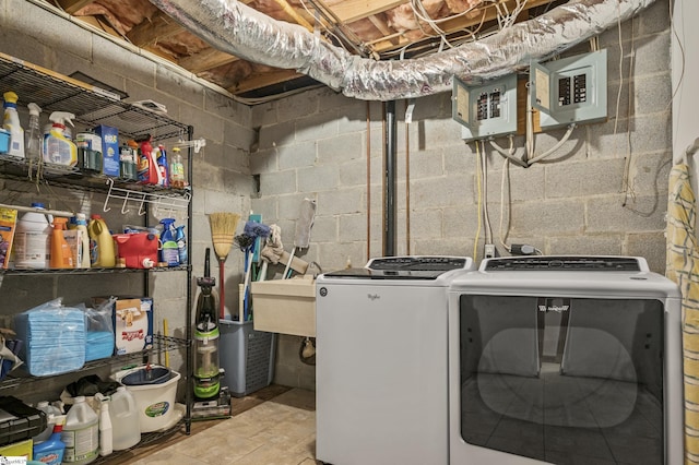 laundry room featuring electric panel, laundry area, washing machine and dryer, and a sink